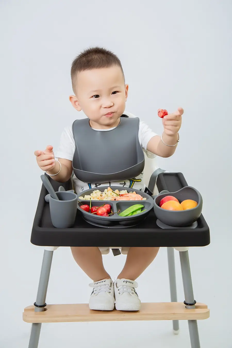 Baby using a SANNYIN silicone full cover mat on an IKEA Antilop high chair